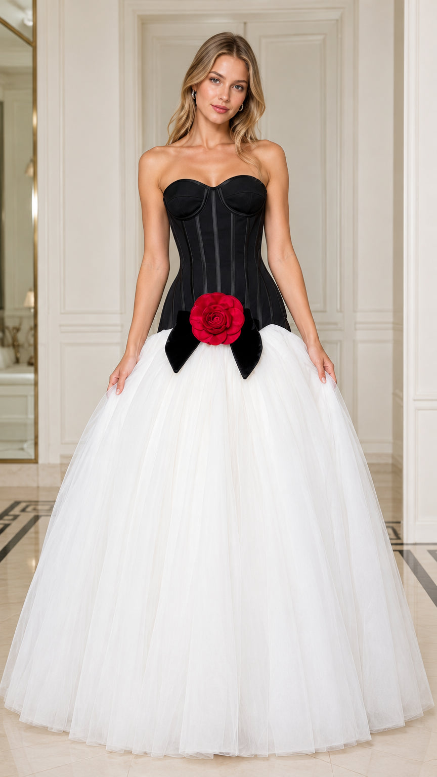 Front view of model wearing black and white strapless corset ball gown with red rose accent