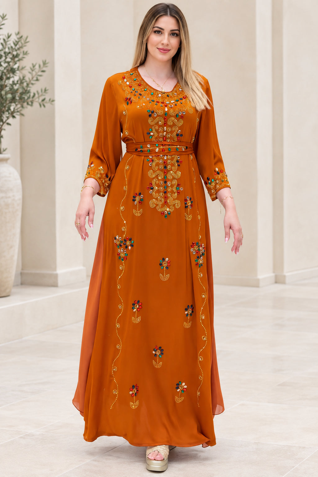 Front view of woman wearing rust orange embellished kaftan maxi dress with tie belt