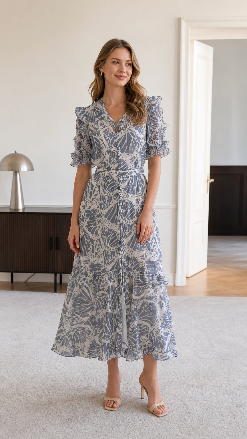Front view of model wearing dusty blue floral ruffle midi dress with tie waist