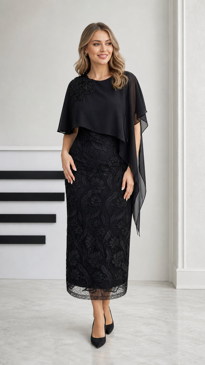 Front view of black embroidered lace midi dress with chiffon cape overlay
