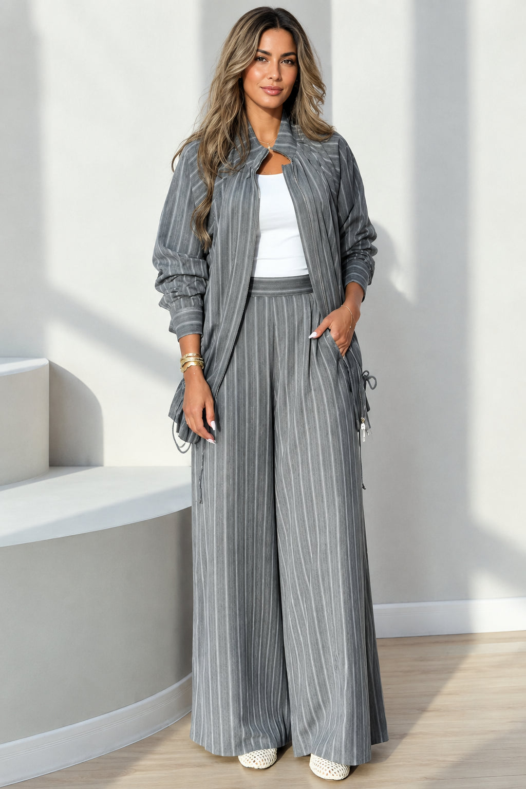 Front full-length view of woman wearing grey pinstripe jacket and wide-leg pants set