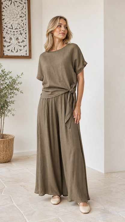 Model wearing olive green two-piece set with side-tie short sleeve top and wide-leg pants front view