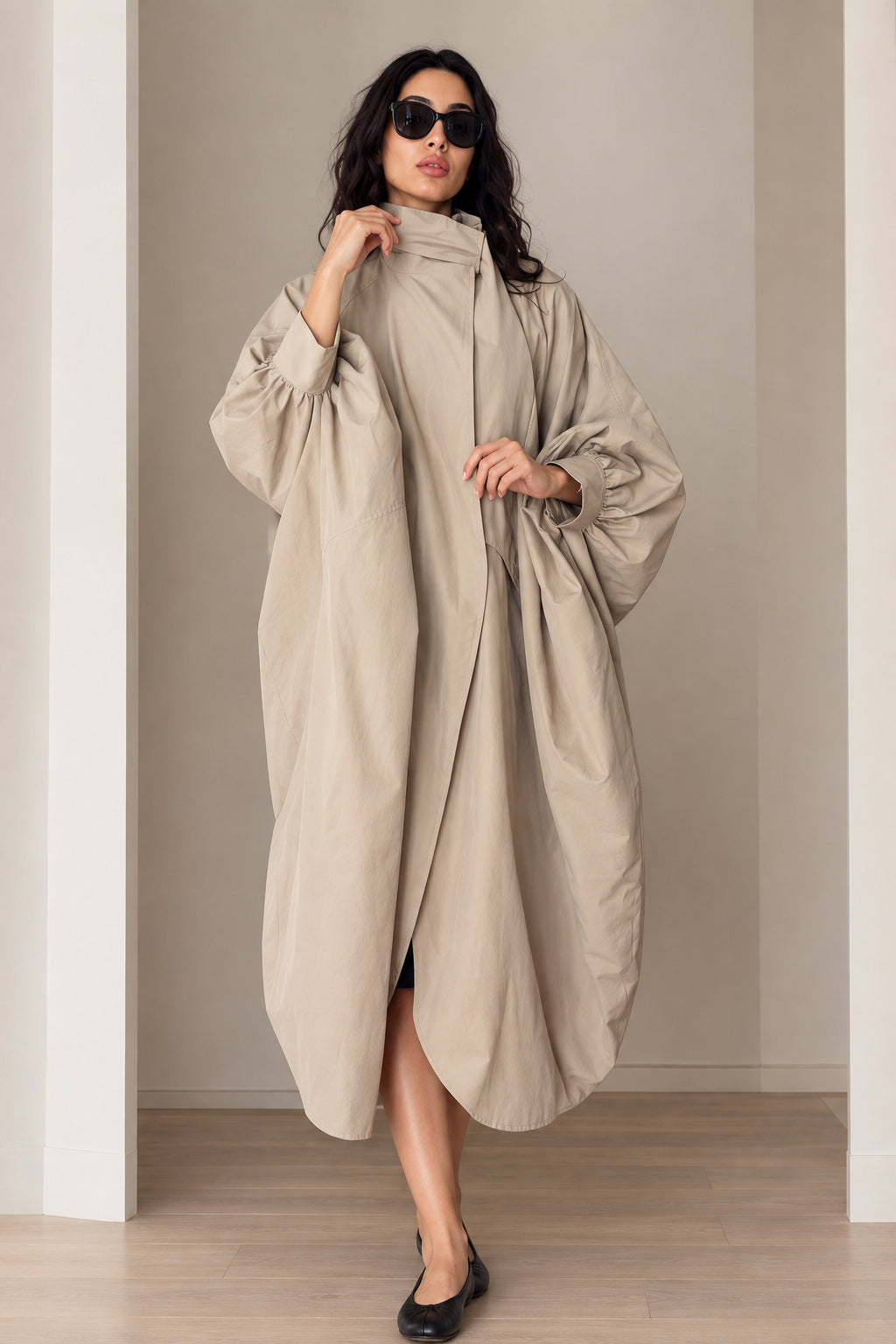 Front view of model wearing beige oversized cocoon duster coat with stand collar