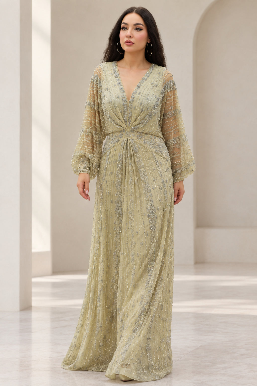 Front view of woman wearing Sage Green beaded long sleeve maxi evening gown with twist front