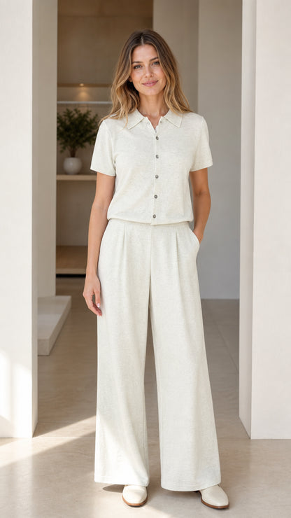 Front view of woman wearing cream short sleeve polo shirt and wide-leg pleated pants set