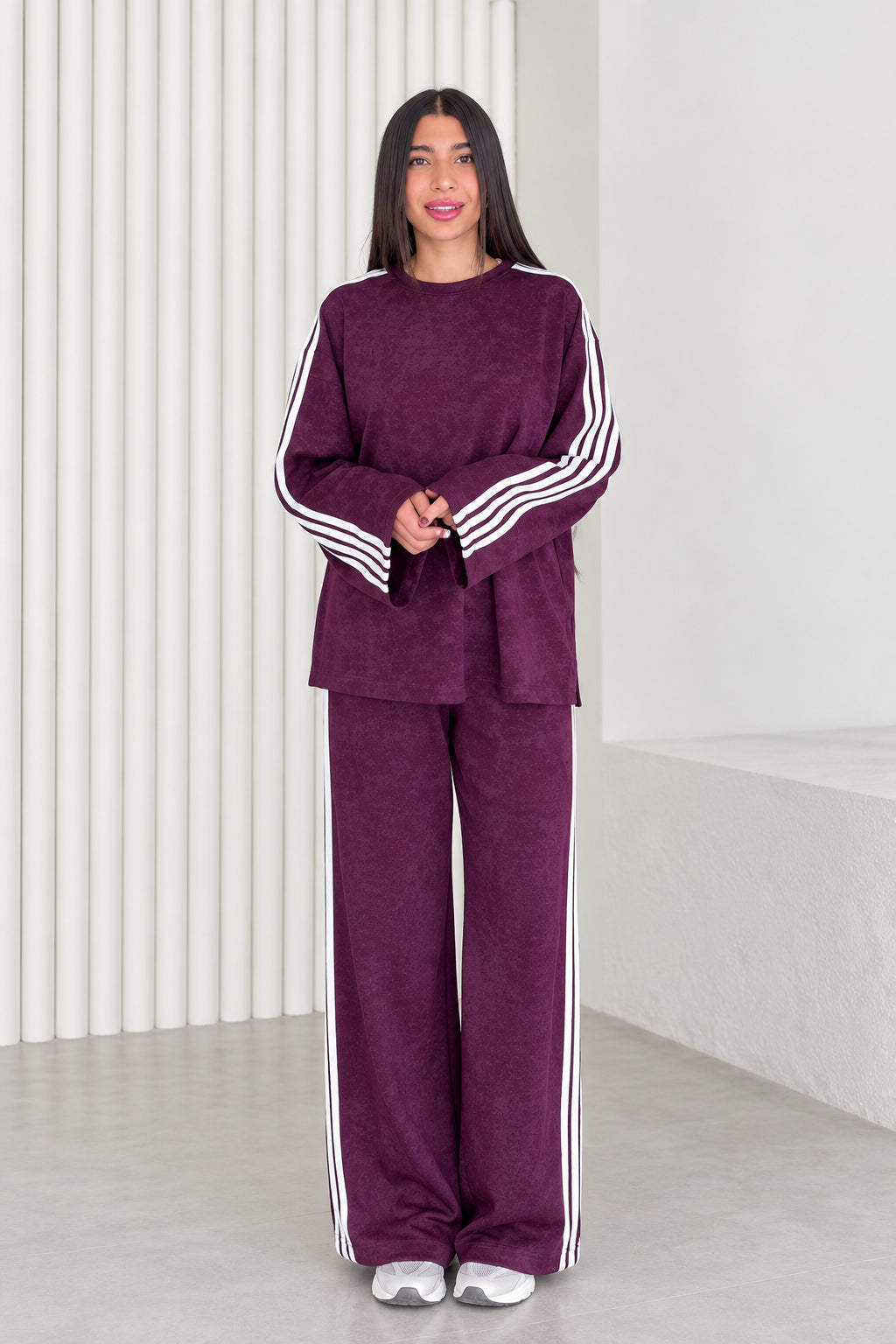 Full front view of model wearing plum two-piece striped lounge set with wide leg pants