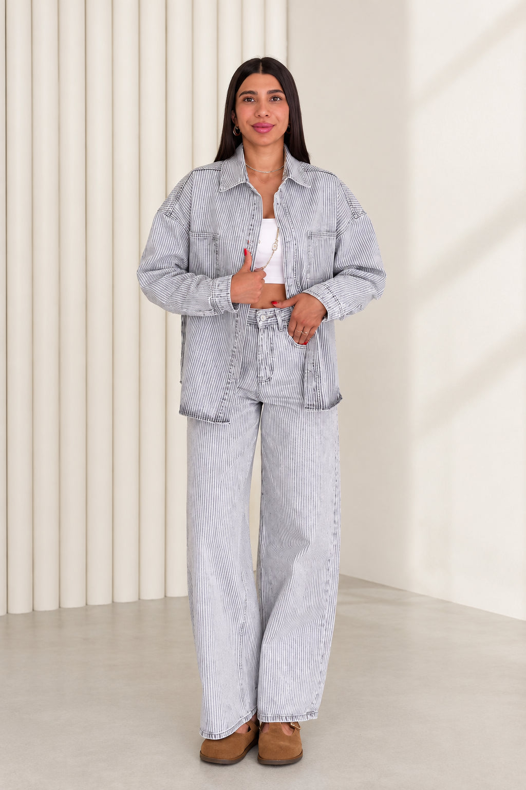 Front view of model wearing light blue striped denim shirt jacket and wide leg pants set