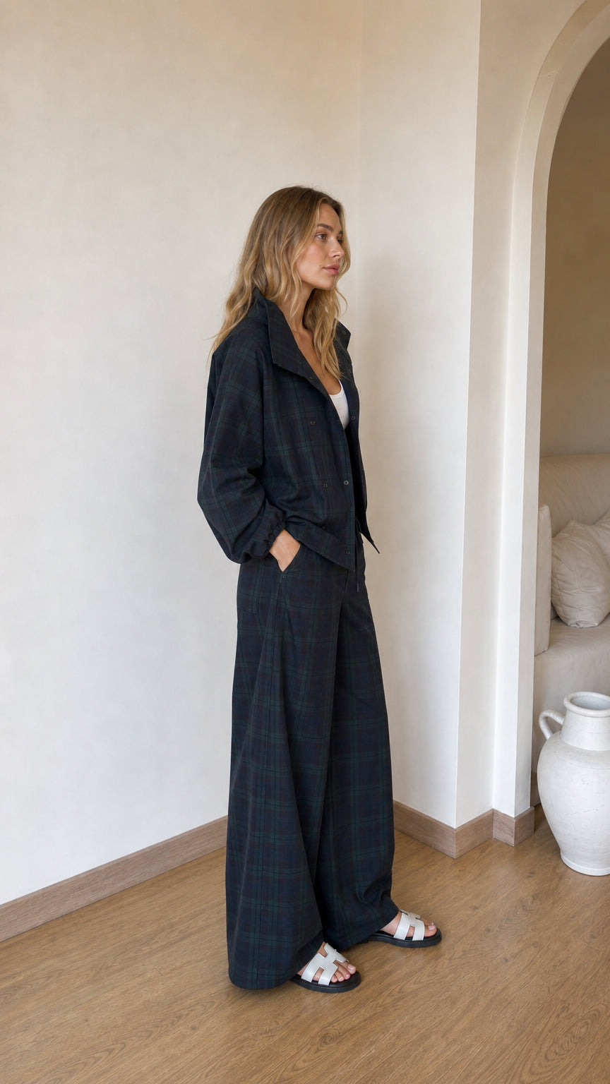 Side profile of model wearing dark plaid two-piece jacket and wide-leg set