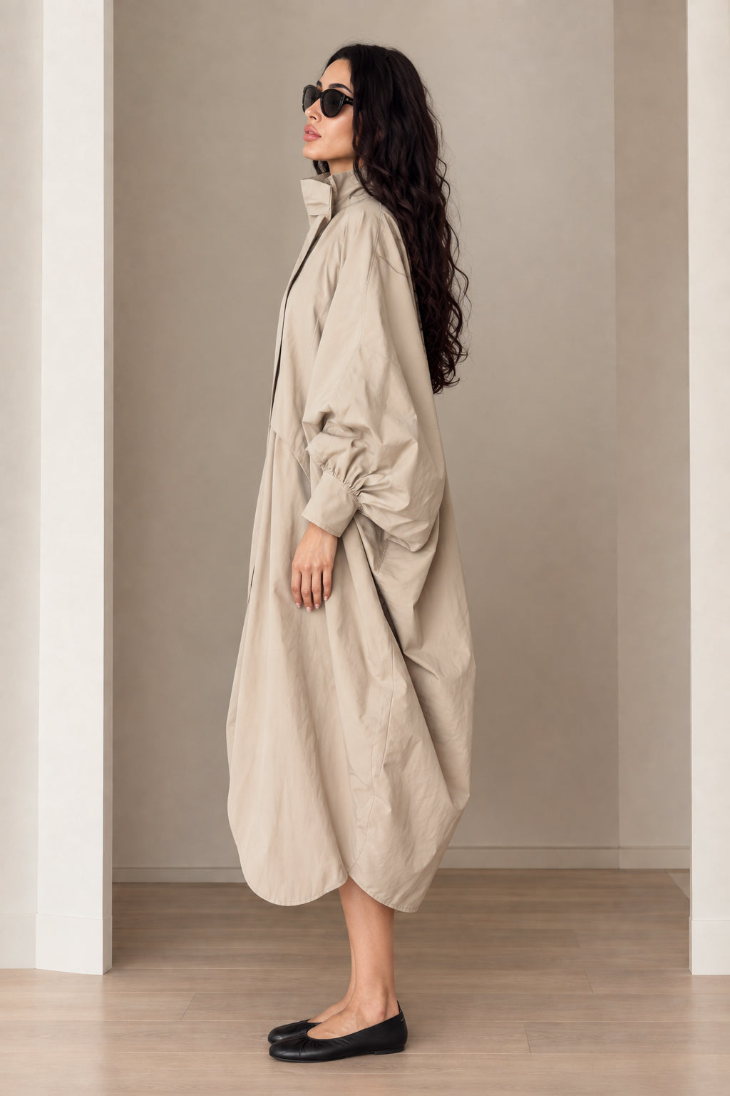 Side profile of beige lantern sleeve cocoon coat showing dramatic volume
