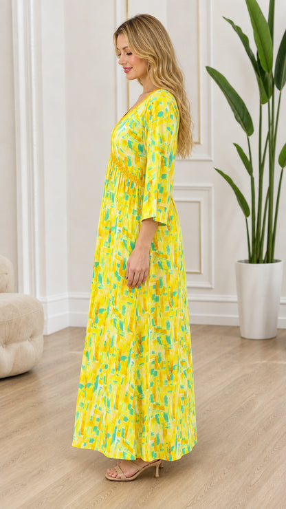 Side profile view of yellow abstract print maxi dress showing flowy silhouette and 3/4 sleeves