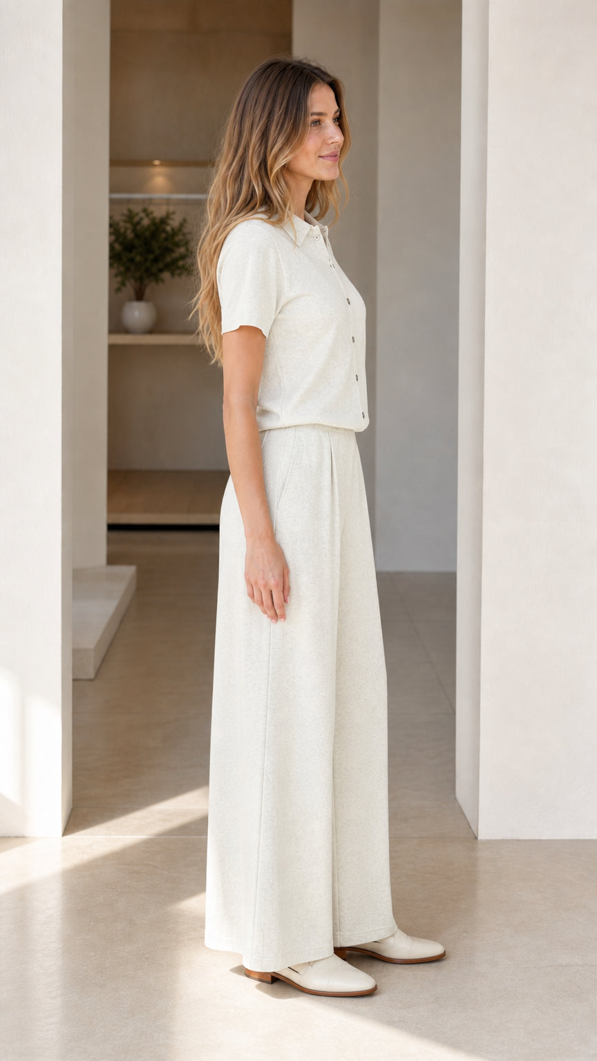 Side profile view of cream short sleeve polo top and wide-leg trousers two-piece set