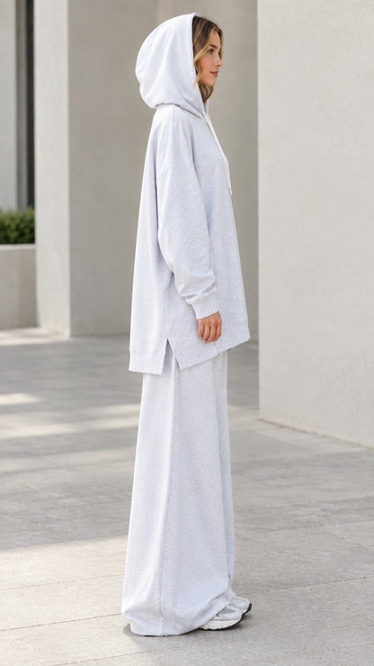 Side profile of woman in light heather grey longline hoodie and wide-leg lounge pants