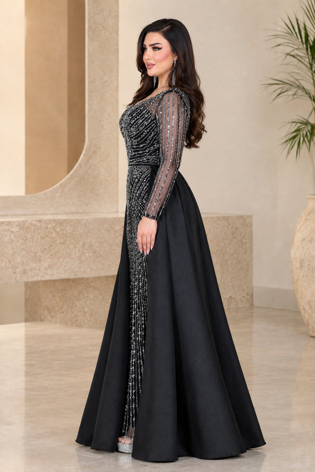 Side profile of black beaded column gown with voluminous satin overskirt