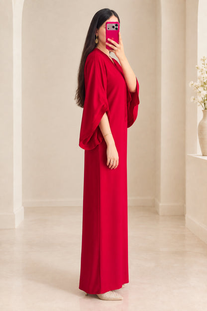 Side angle of woman in red modest kaftan dress showing draped sleeve design