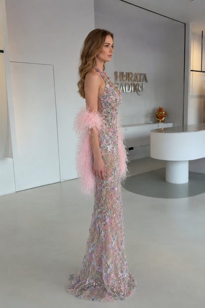Side profile view of Blush Pink embroidered halter maxi gown with pink feather wrap