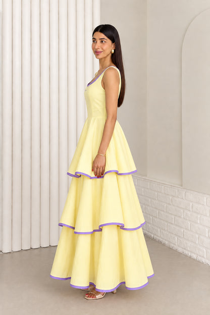 Model in pastel yellow tiered maxi dress showing side profile