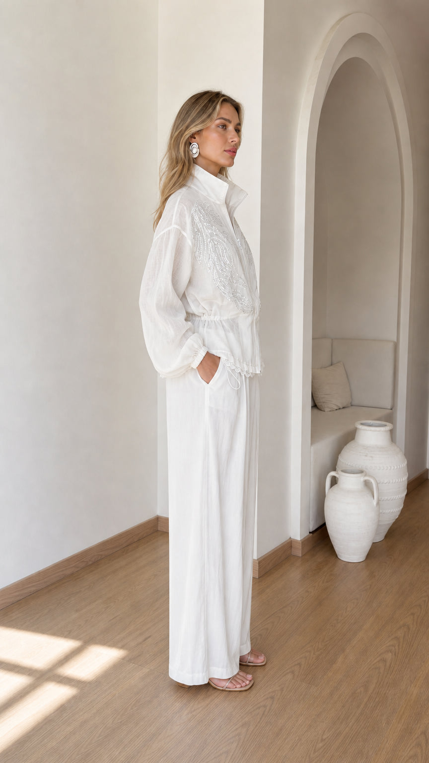 Side view of woman wearing white embroidered two-piece pant set