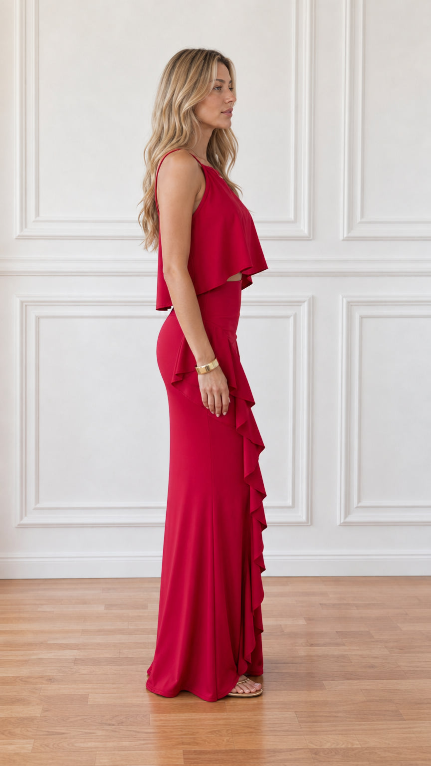 Side view of woman wearing red matching crop top and ruffle maxi skirt set