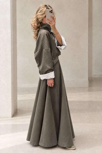 Side profile of woman in Olive Green high-neck jacket and flowing maxi skirt set