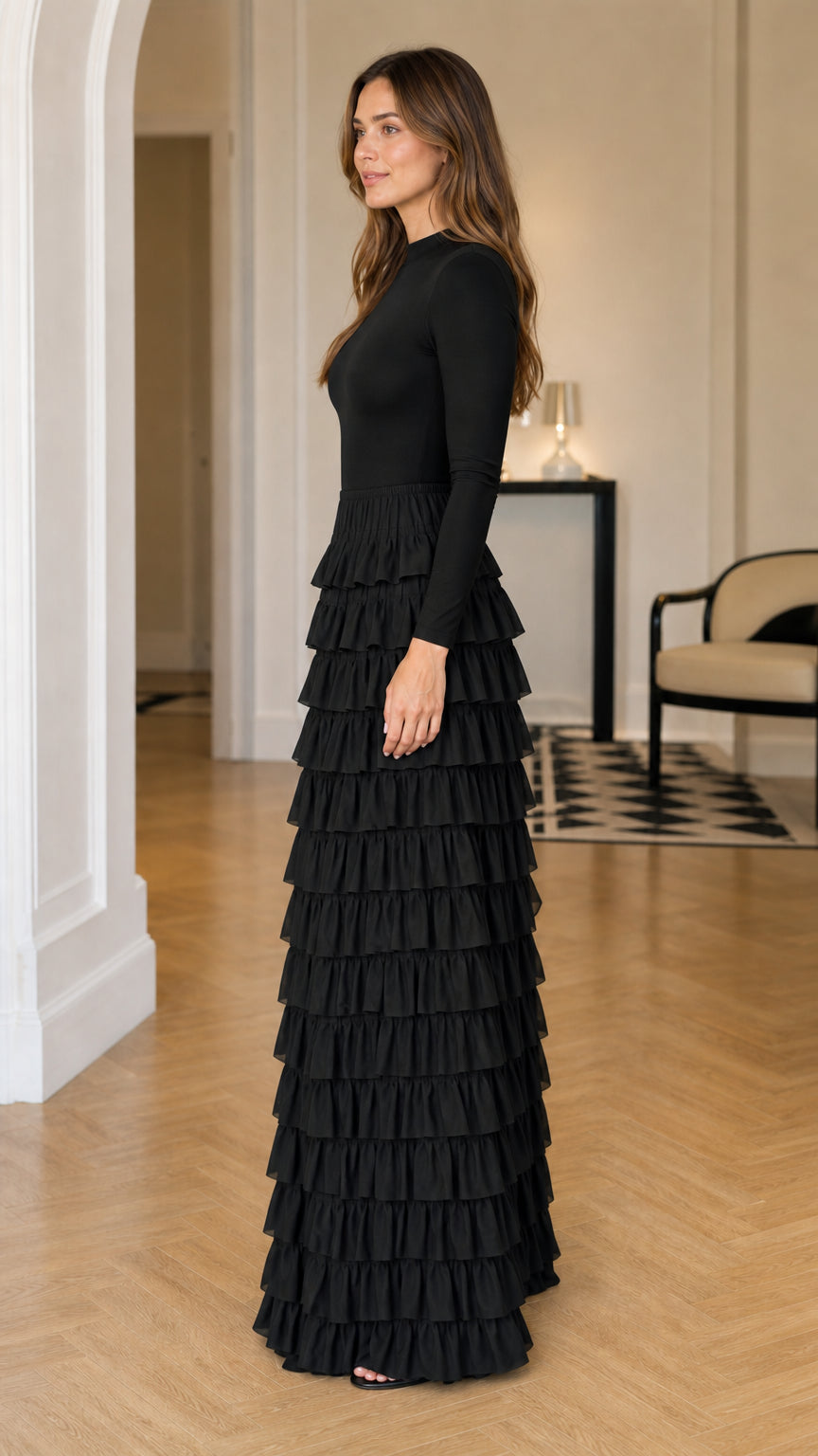 Side profile view of a woman wearing a black long sleeve cascading ruffle maxi dress