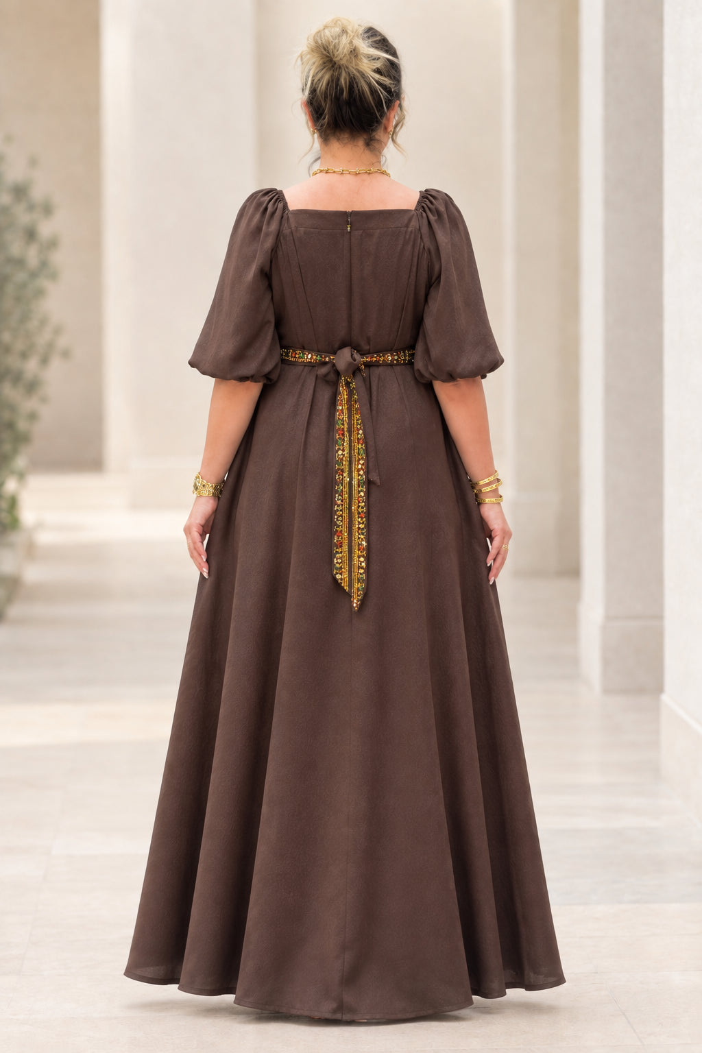 Back view of brown maxi dress showing back zipper and tied waist sash