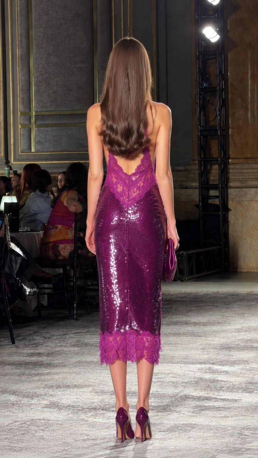 Back view of model showcasing backless halter neck design and lace accents on magenta sequin midi dress