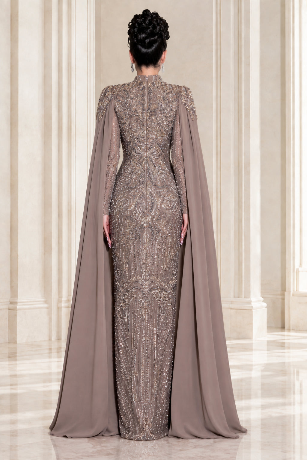 Back view of taupe high neck evening gown showing sweeping cape detail