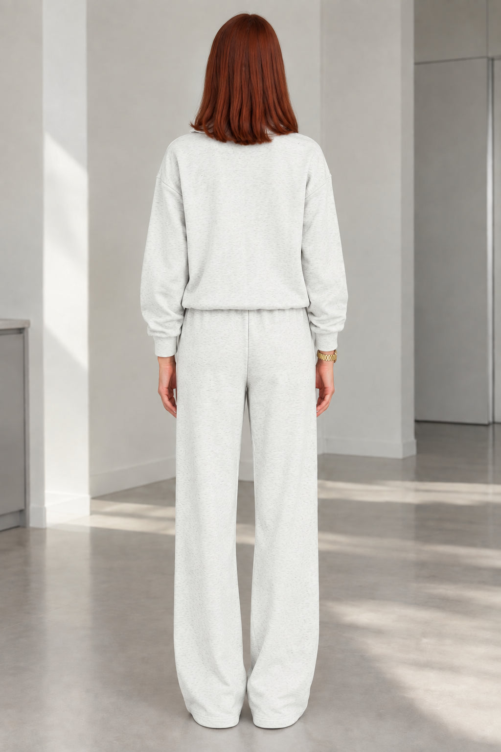 Back view of woman wearing Heather Grey zip jacket and wide-leg trousers