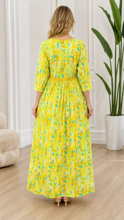 Back view of model wearing yellow patterned maxi dress with gathered empire waist