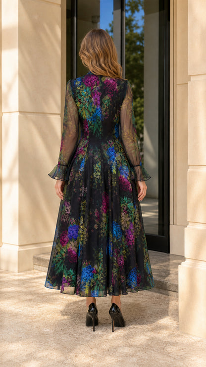 Back view of model wearing black floral maxi dress showing tailored waist and skirt