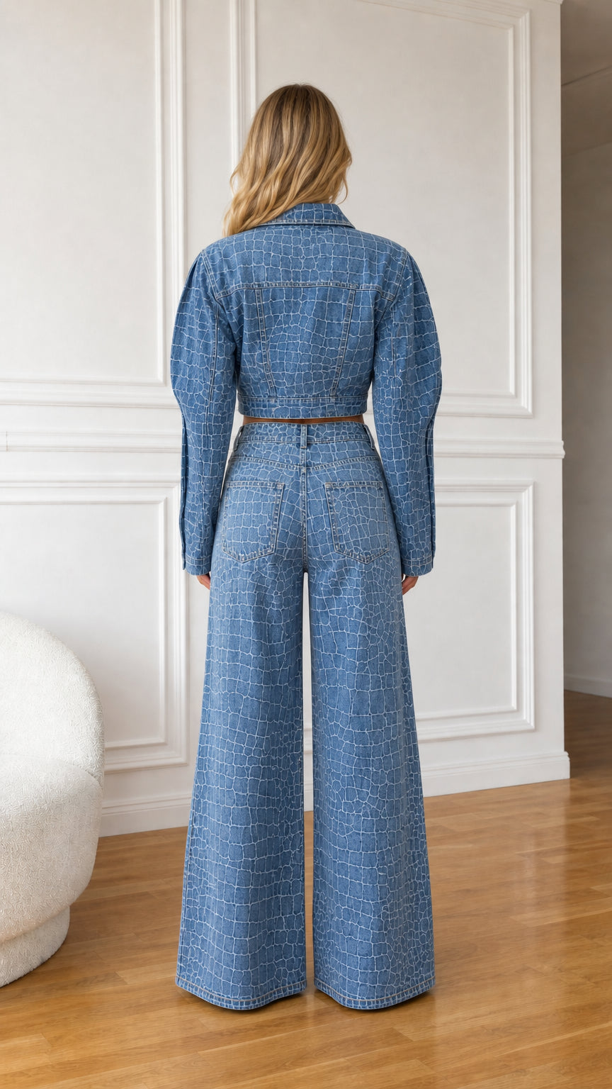 Back view of model wearing denim blue puff sleeve cropped jacket and wide leg jeans set