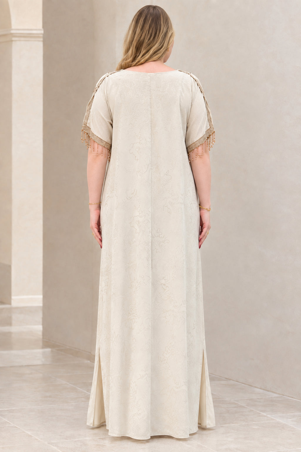 Back view of model in elegant champagne full-length kaftan gown