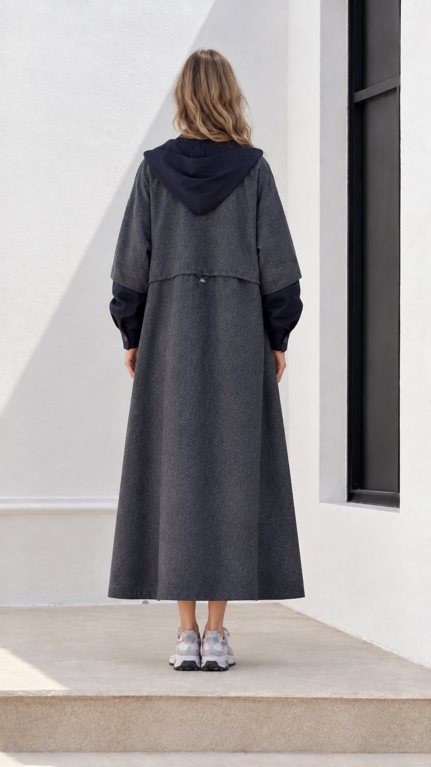 Back view of woman wearing charcoal grey hooded maxi overcoat showing back vent