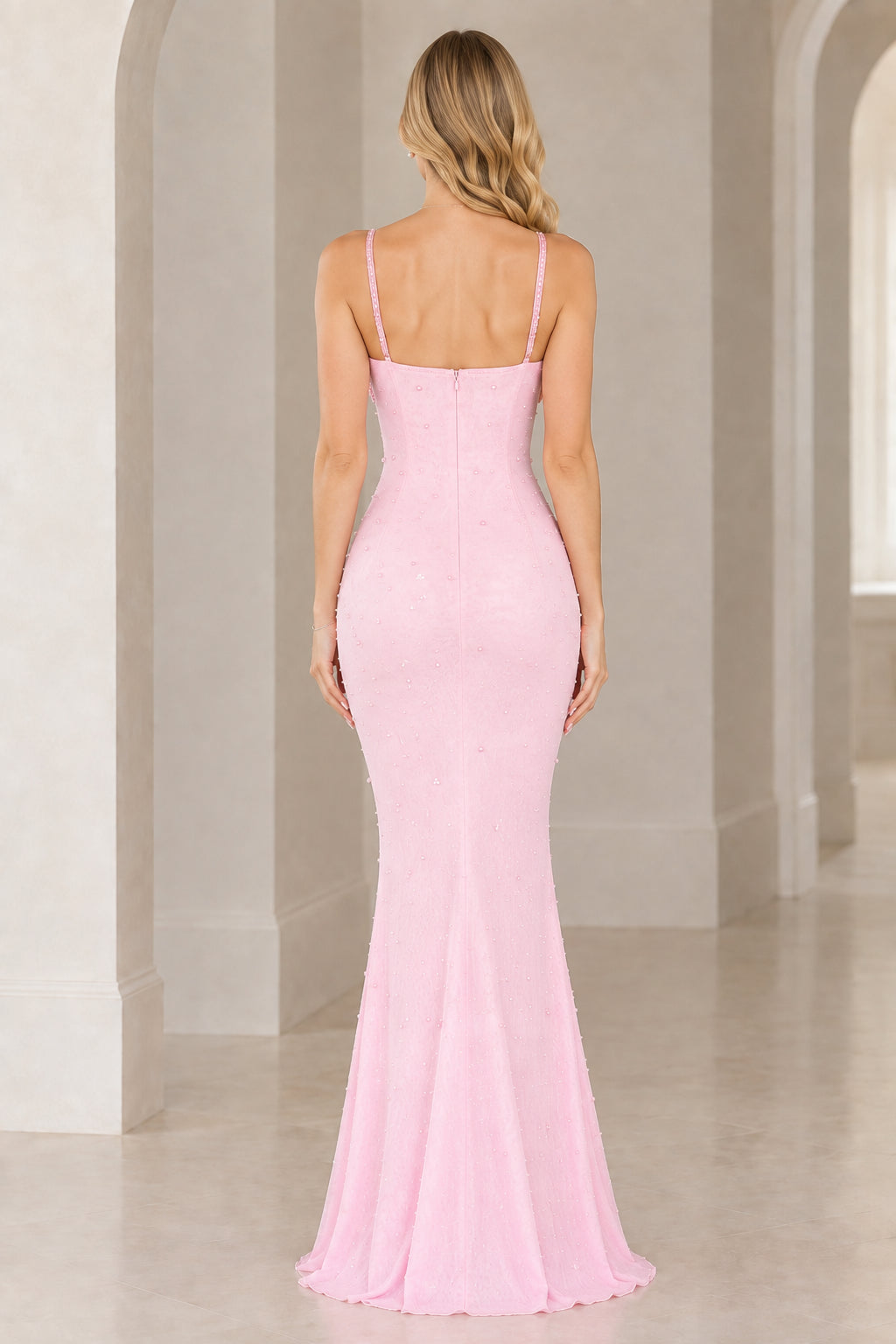 Back view of model in pink fitted mermaid evening dress with spaghetti straps