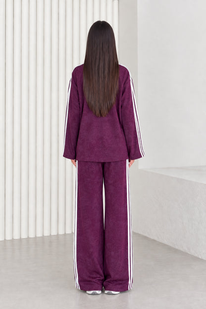 Back view of model in plum two-piece crewneck top and wide leg pants set