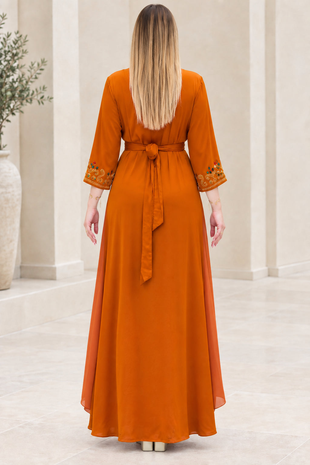 Back view of rust orange kaftan maxi dress with tied waist sash