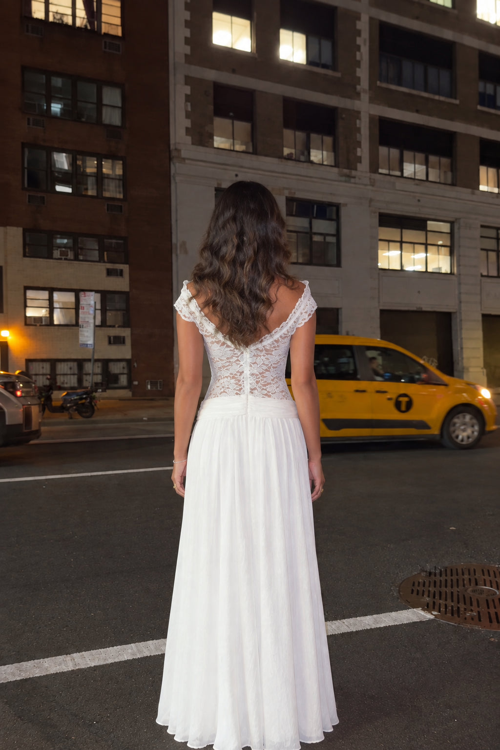 Back view of woman wearing white lace cap-sleeve maxi gown