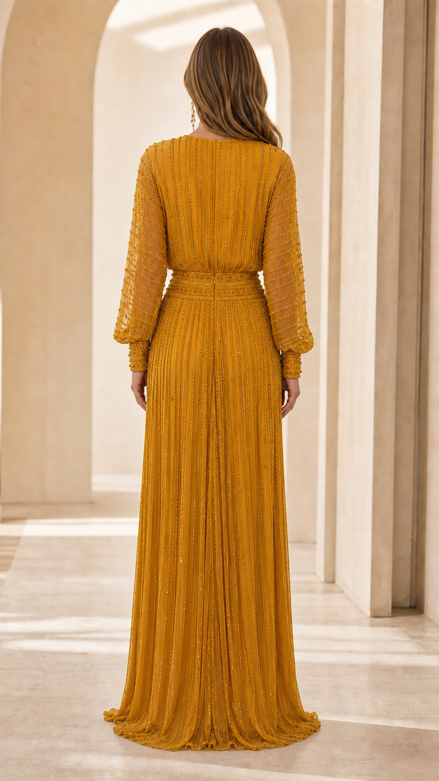 Back view of model showing pleated detailing on mustard yellow gown
