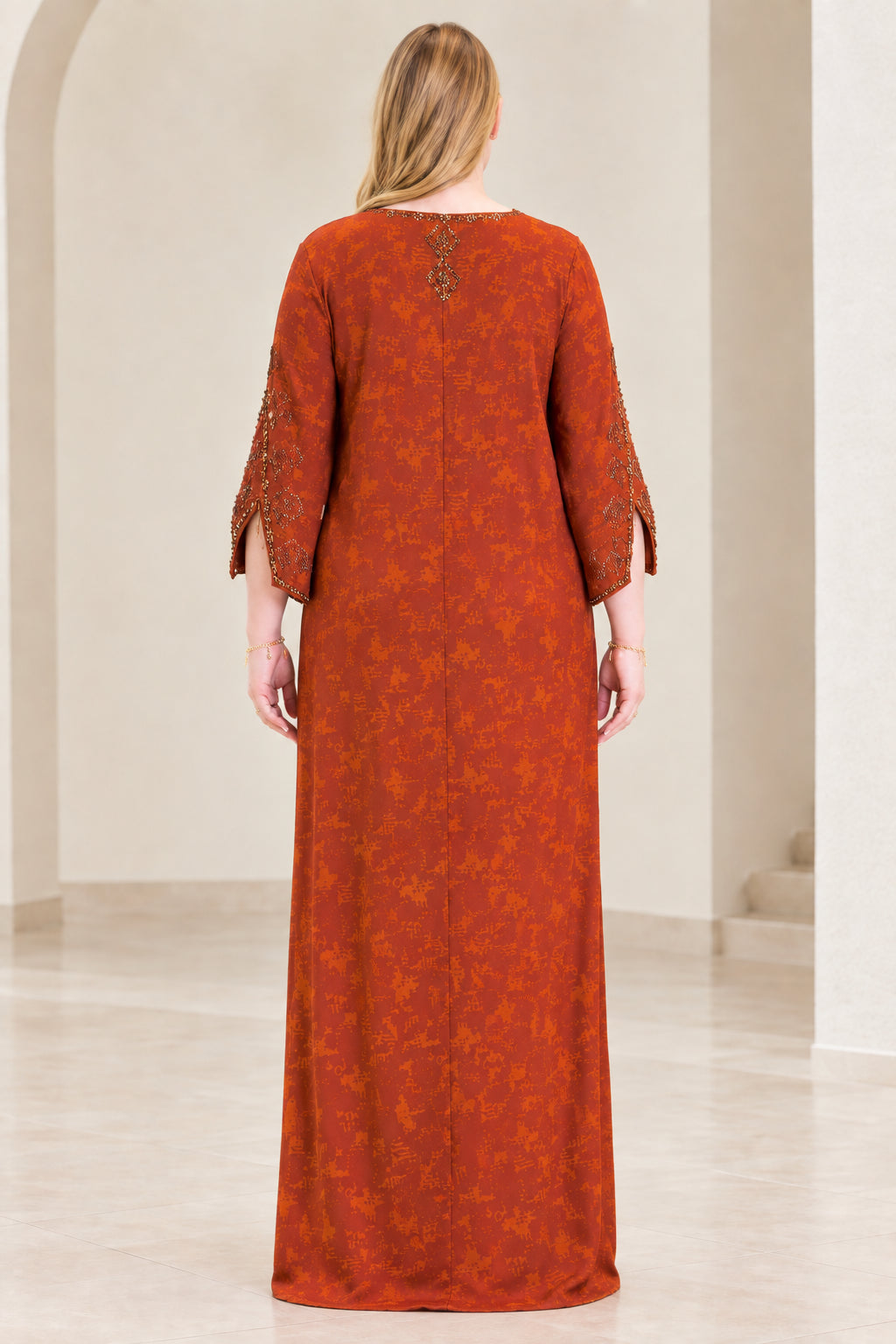 Back view of woman wearing rust orange textured maxi kaftan dress