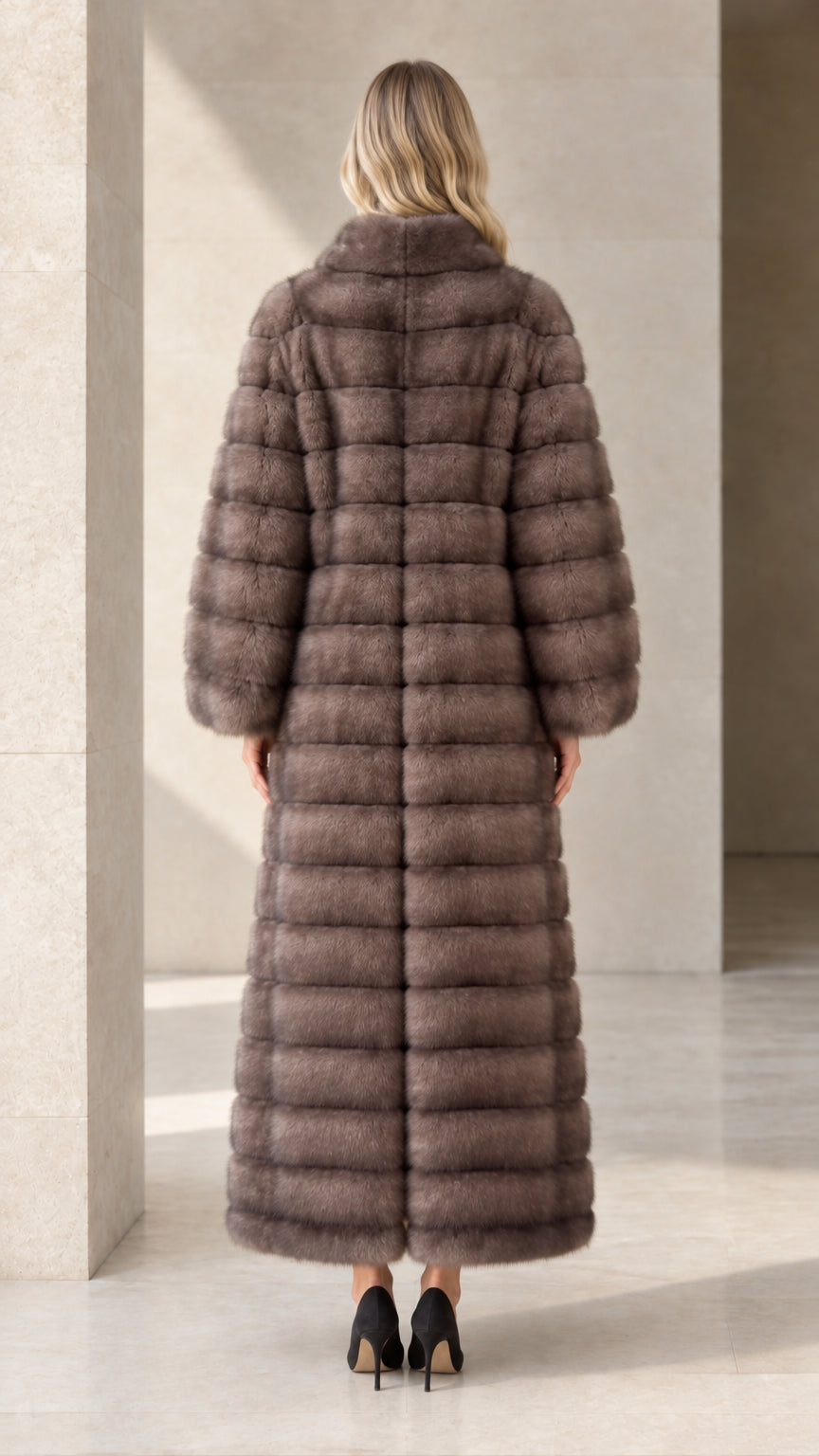 Back view of model showcasing the longline cut of the taupe faux fur maxi coat