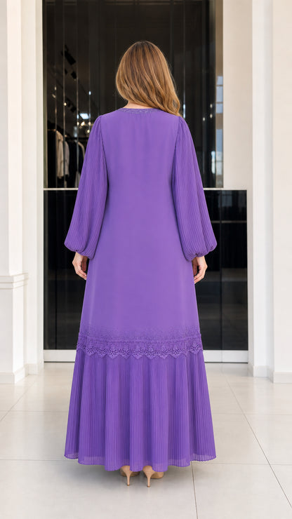 Back view of woman wearing purple flowing maxi dress with pleated hem tier