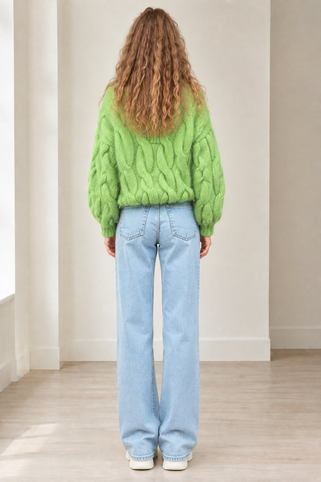 Back view of model wearing lime green cable knit sweater