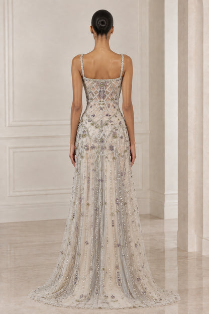 Back view of model showcasing square back and flowing train of Silver Champagne gown