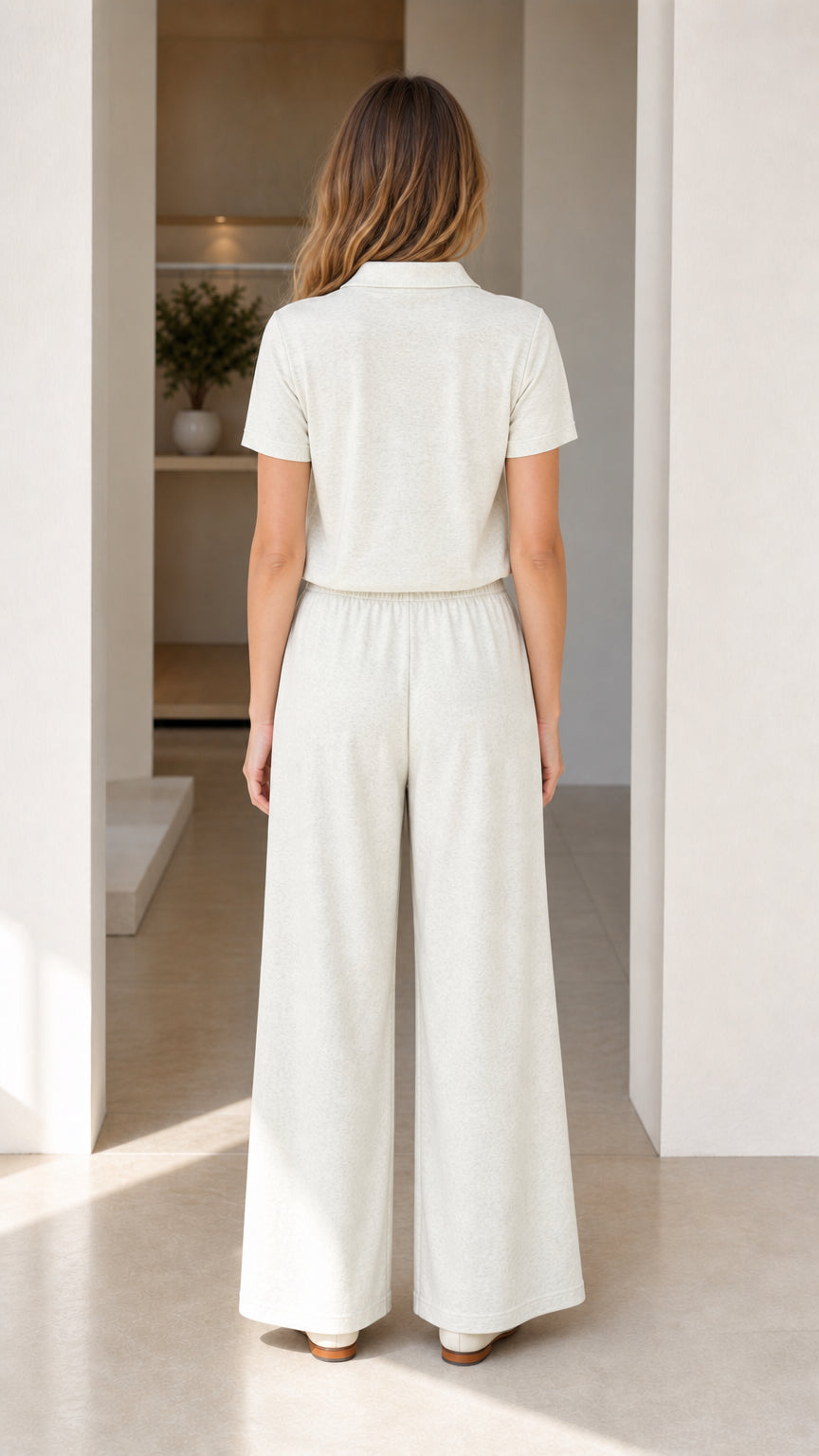 Back view of woman wearing cream knit polo shirt and matching wide-leg pants