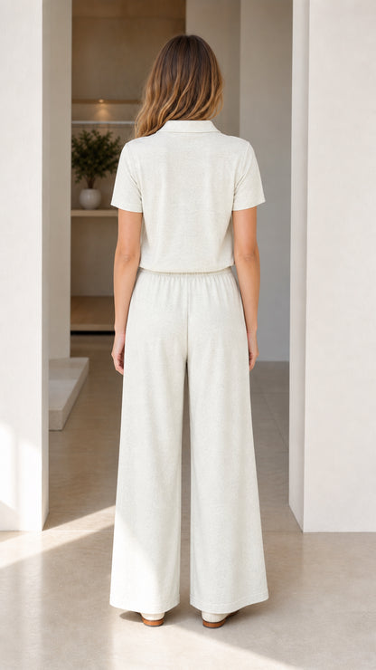 Back view of woman wearing cream knit polo shirt and matching wide-leg pants