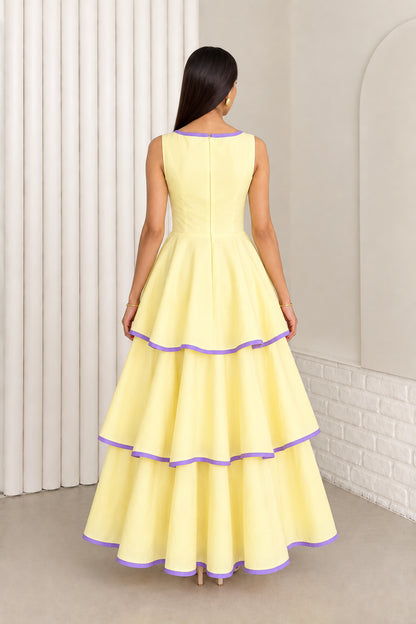 Back view of model in pastel yellow sleeveless tiered maxi dress