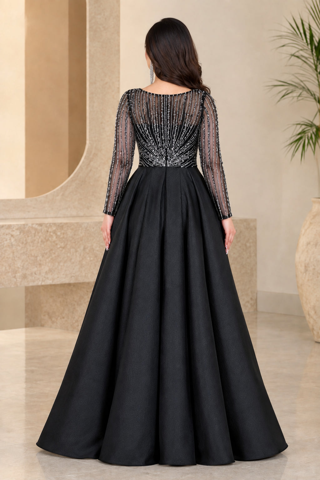 Back view of black sequined evening gown highlighting overskirt pleats