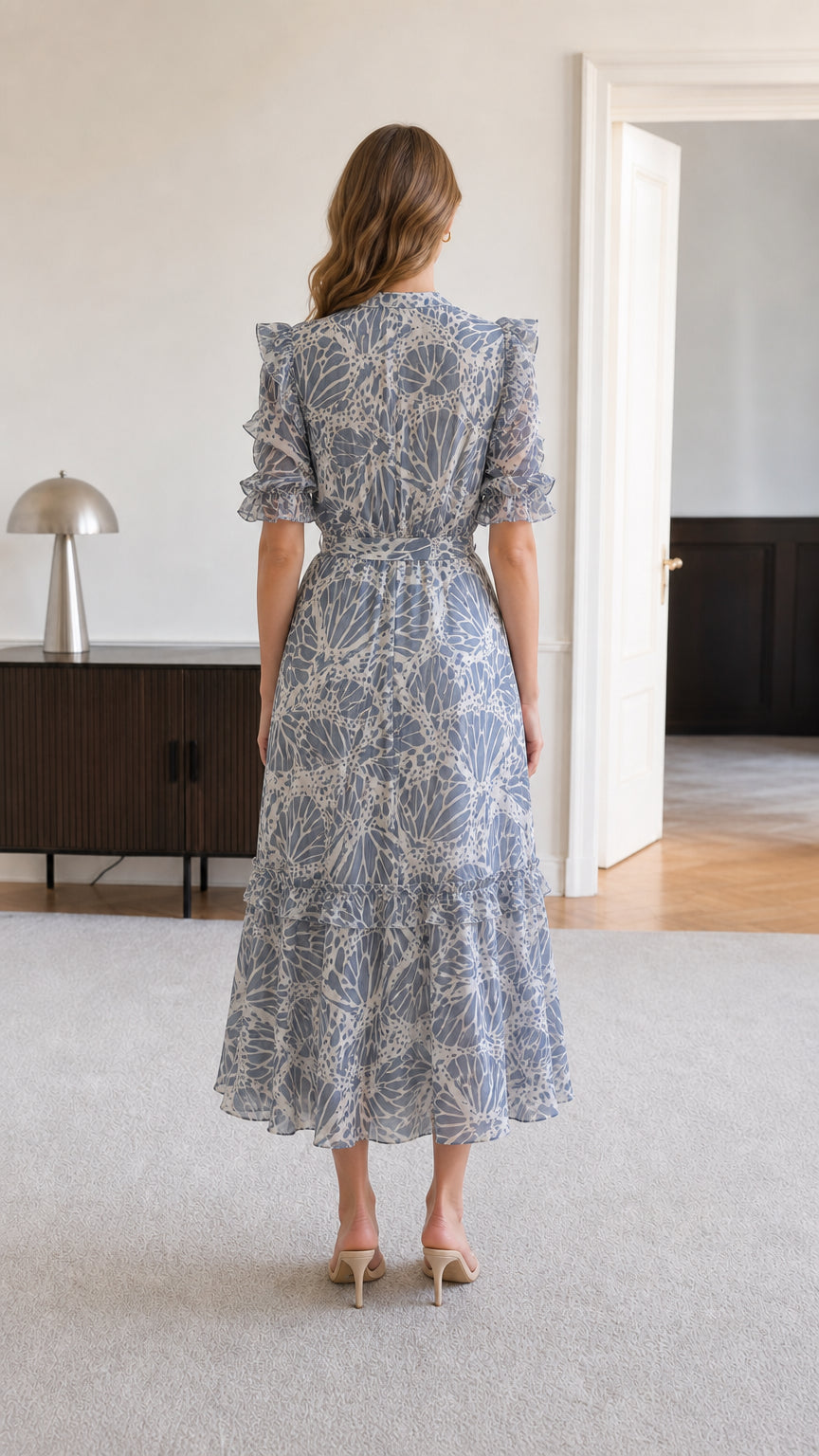 Back view of dusty blue tiered midi dress showcasing graceful drape