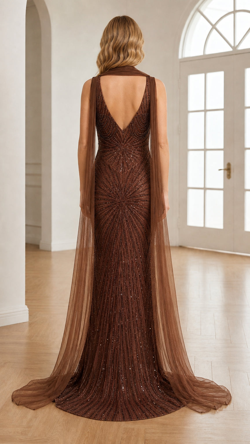 Back view of chocolate brown beaded gown showing open V-back and tulle cape