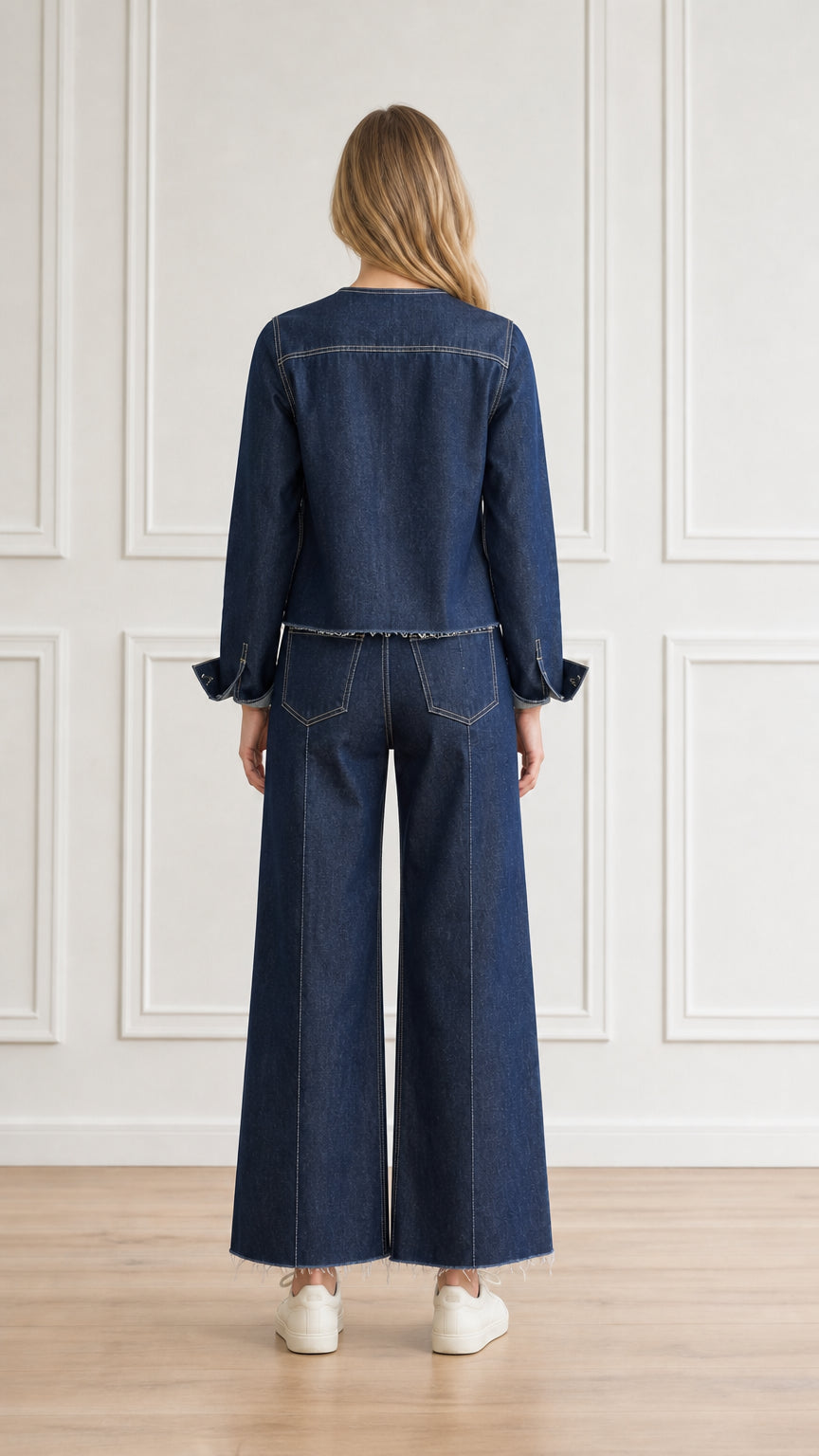Back view of model wearing dark blue denim jacket and wide-leg trousers